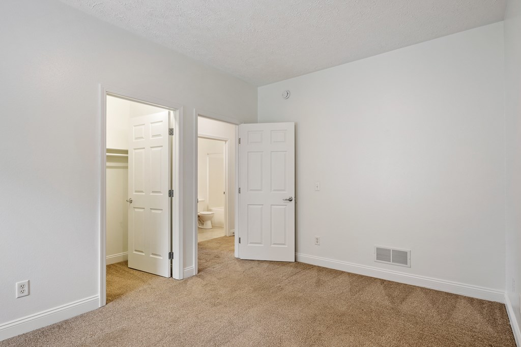 A room with two white doors and a carpeted floor.