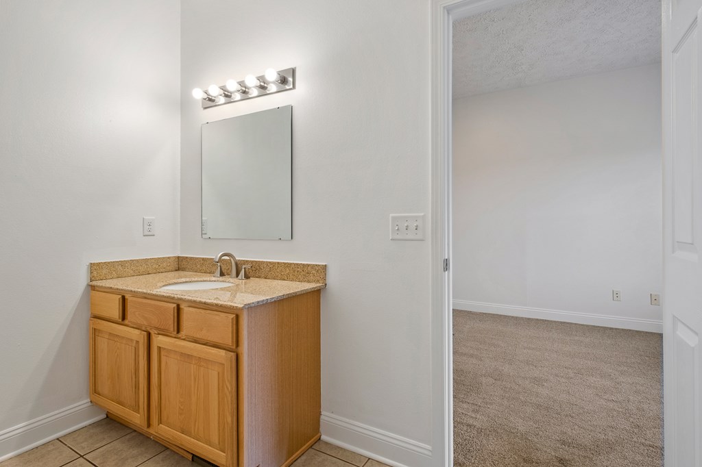 A bathroom vanity with a mirror and lights above it.