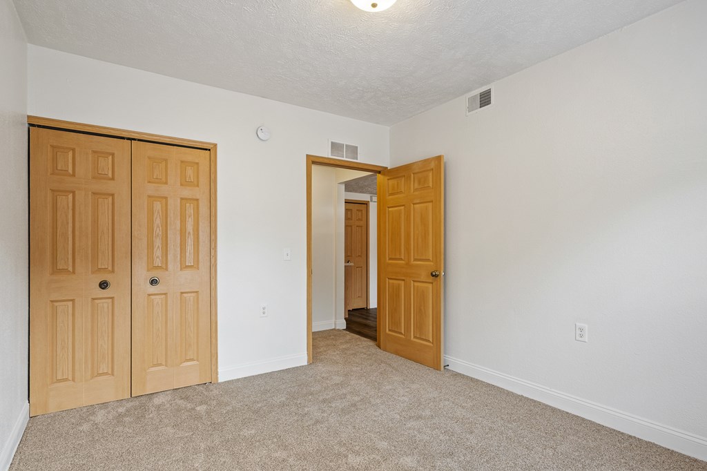 A room with two doors and a carpeted floor.