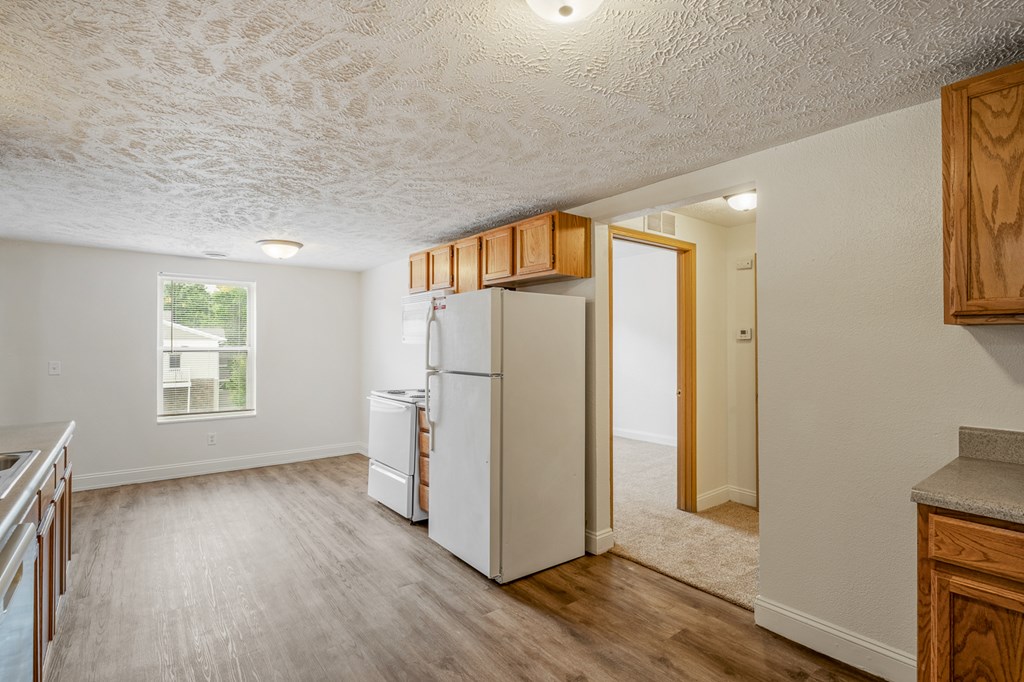 A kitchen with a white fridge and wooden cabinets.