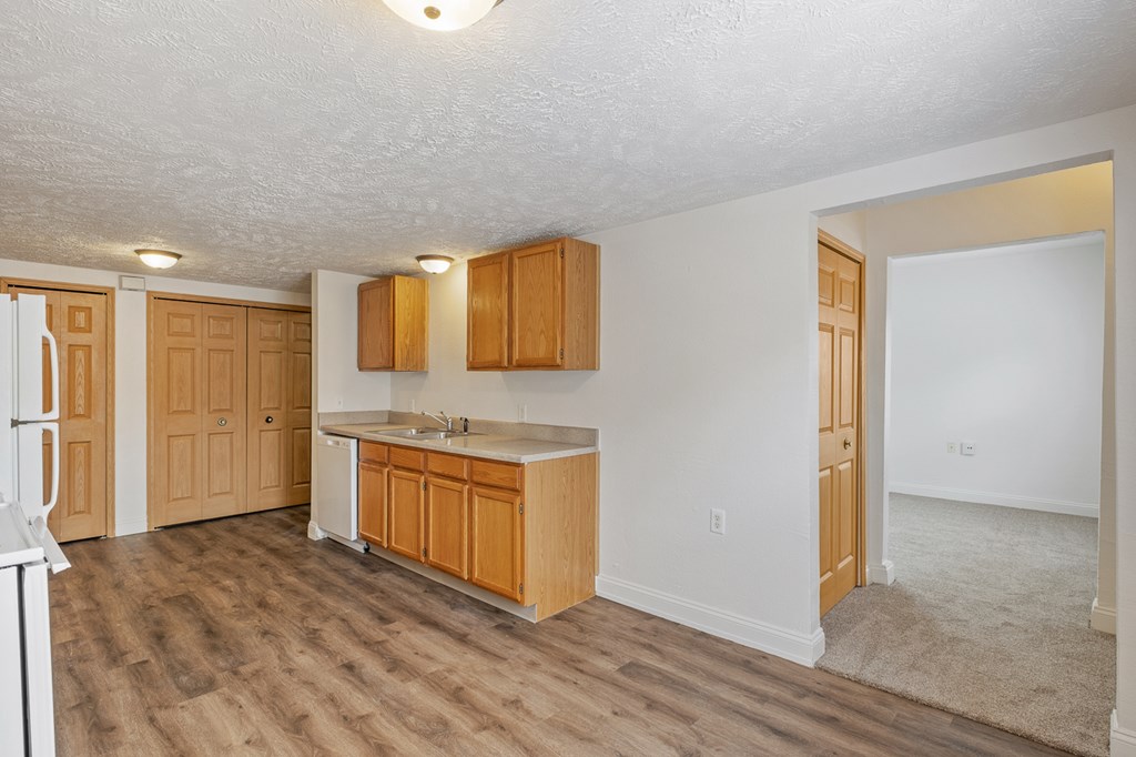 A kitchen with wooden cabinets and a white fridge.