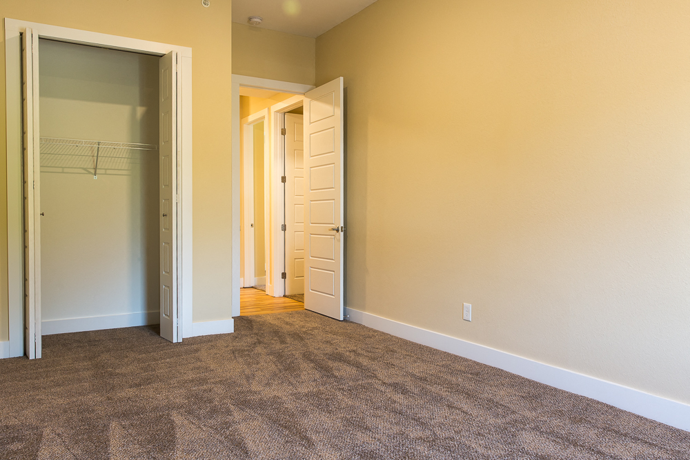 an empty room with a closet and an open door