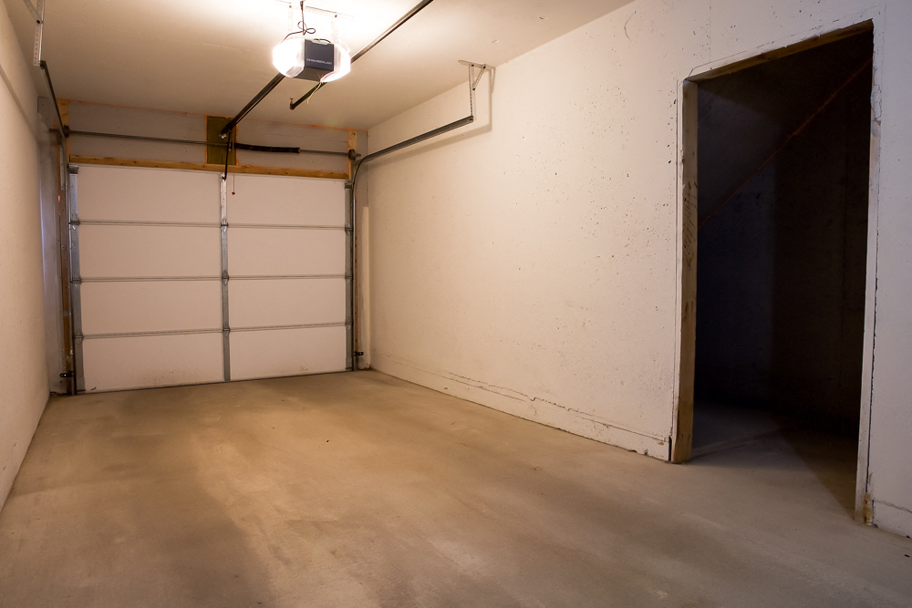 the inside of a garage with a white wall and a door