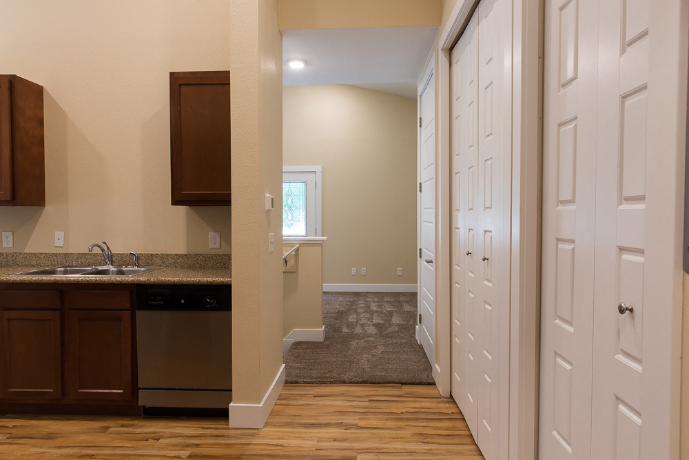 a view of a kitchen and a hallway with white closets