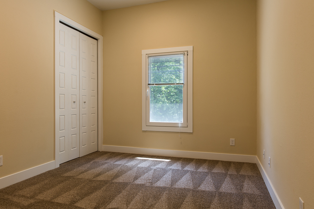 an empty room with carpet and a window