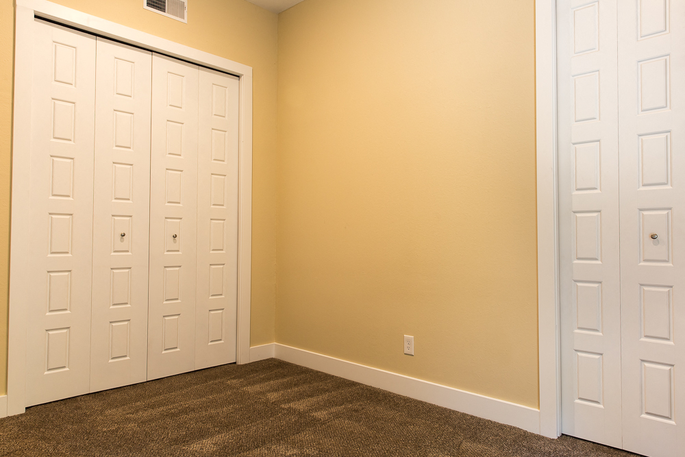 a bedroom with two closets and two doors