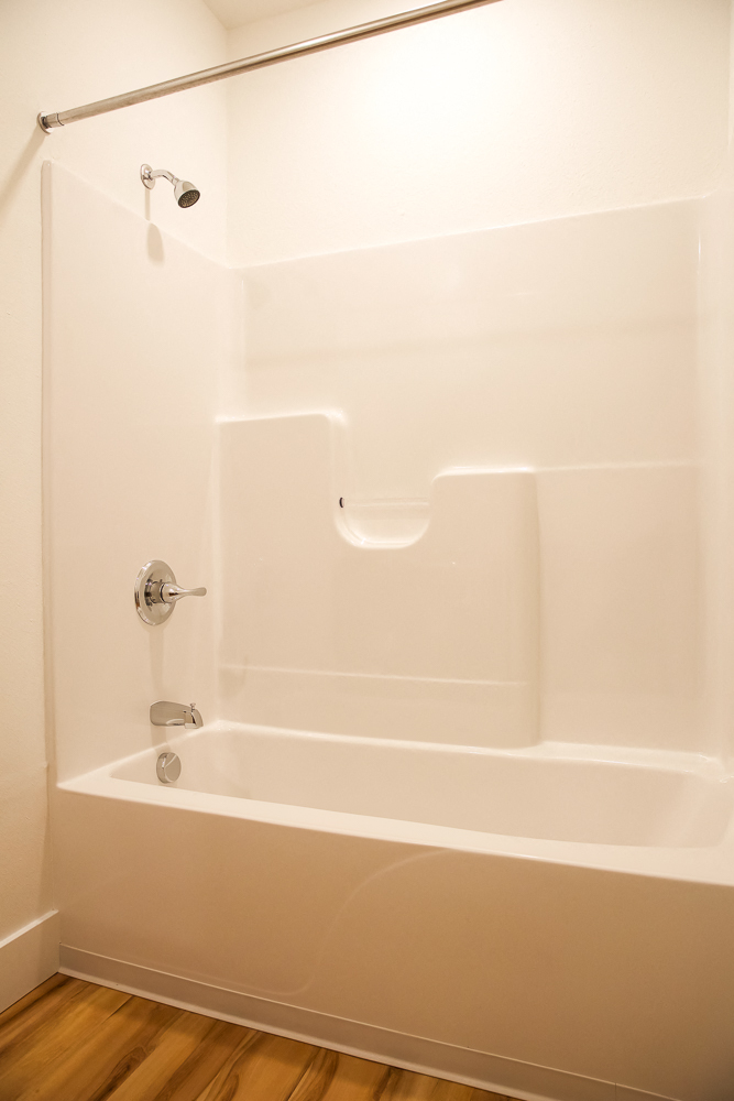 a white bathroom with a tub and a shower