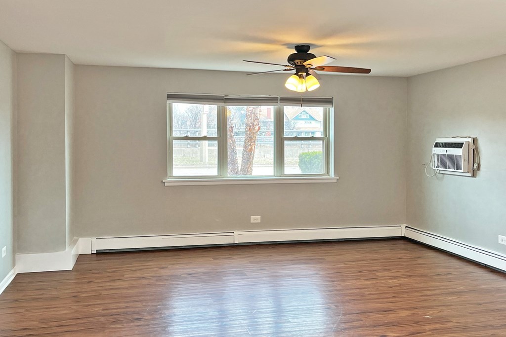 A room with a ceiling fan and a window.