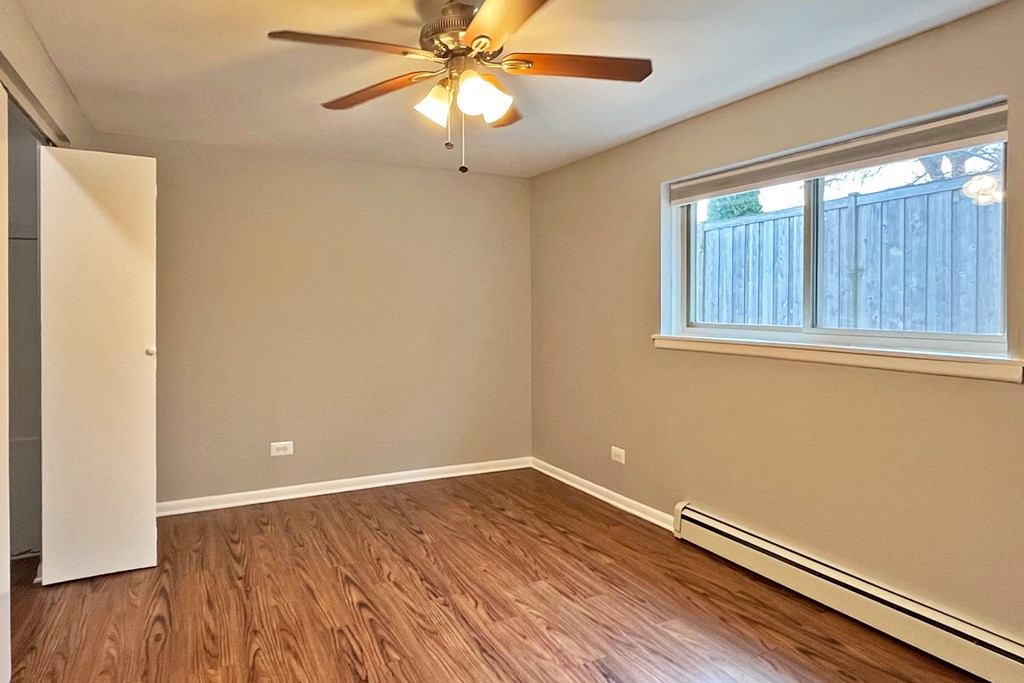A room with a ceiling fan and a window.