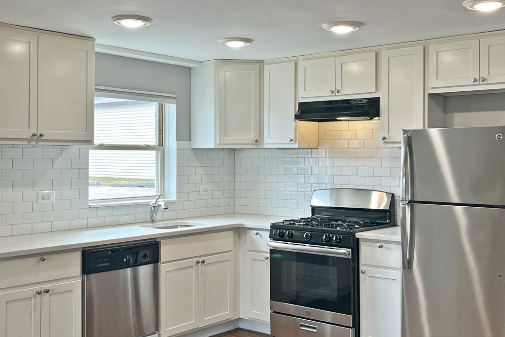 A kitchen with a stove, oven, and refrigerator.