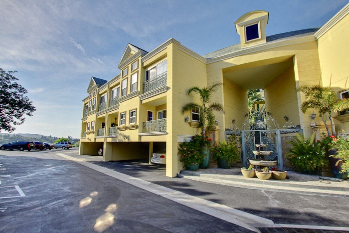 a large yellow building with a fountain in front of it