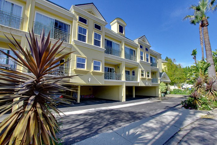 a large yellow apartment building with a street in front of it