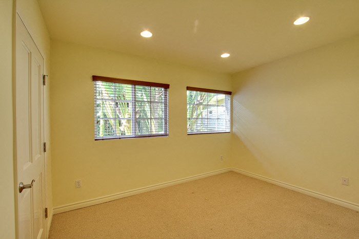 a large empty room with two windows and a door