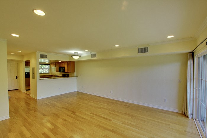 an empty living room with a hard wood floor