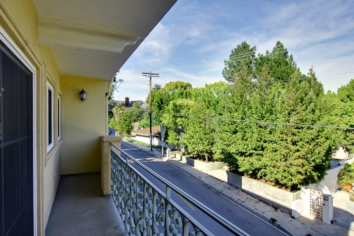 a balcony with a view of a street and trees
