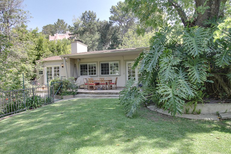 the front of the house with a lawn and a patio