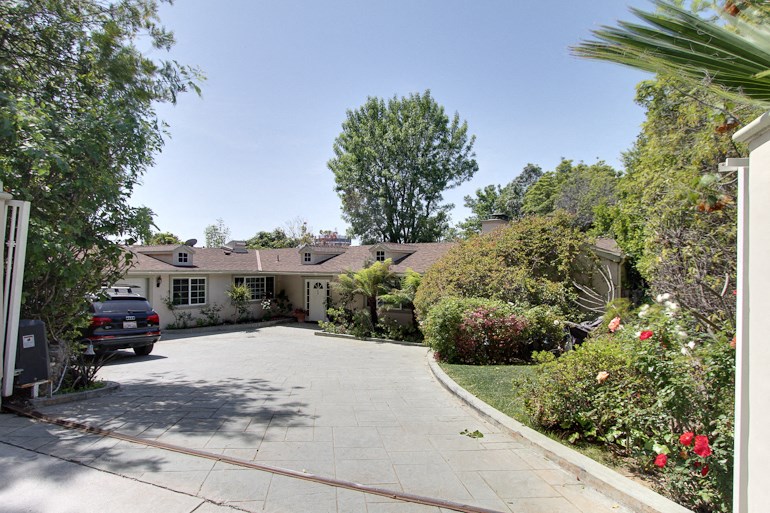 a house with a driveway and a car in front of it