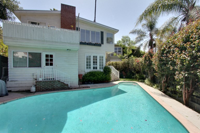 a large pool in front of a white house