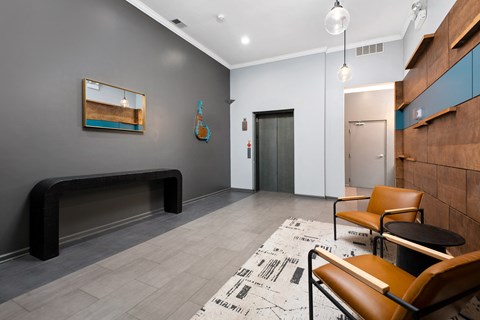 a lobby with chairs and a table and a door