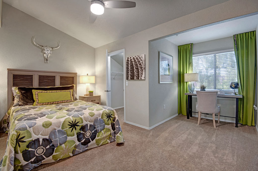 a bedroom with a bed and a desk with a chair