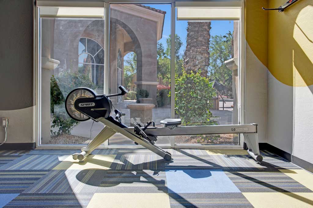 a workout room with a weights bench in front of a window