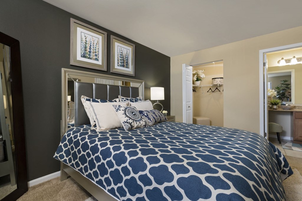 a blue and white bed in a bedroom with a closet