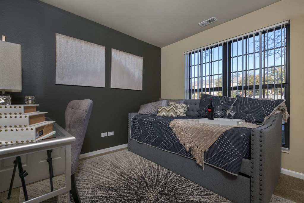 a bedroom with a bed and two windows