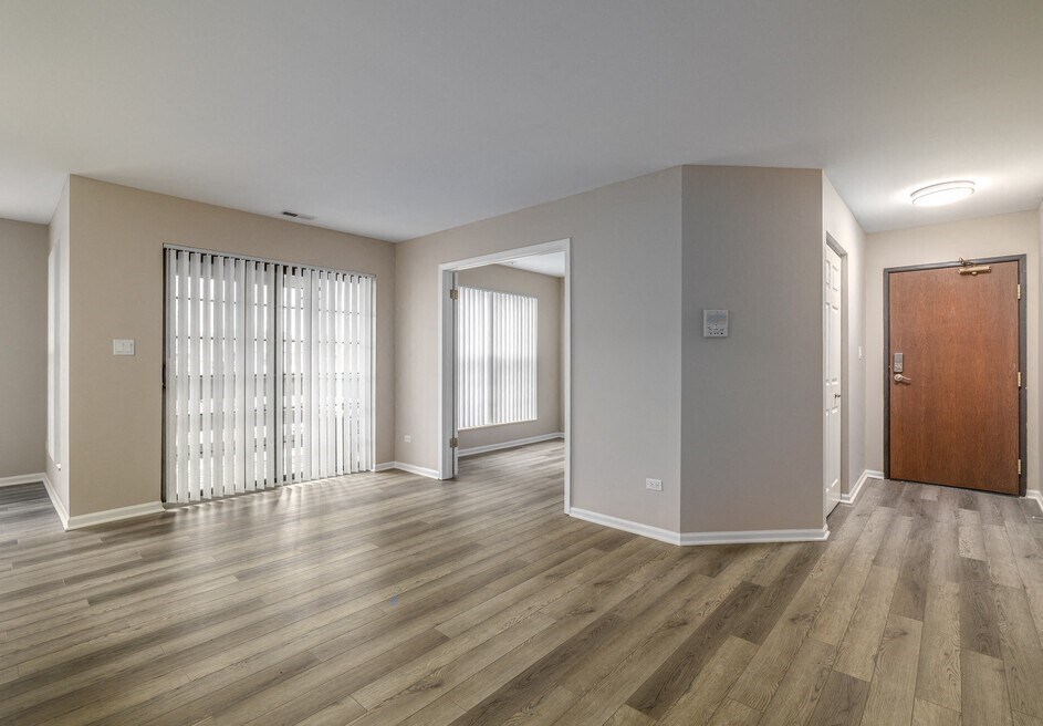 an empty living room with wood flooring and sliding glass doors