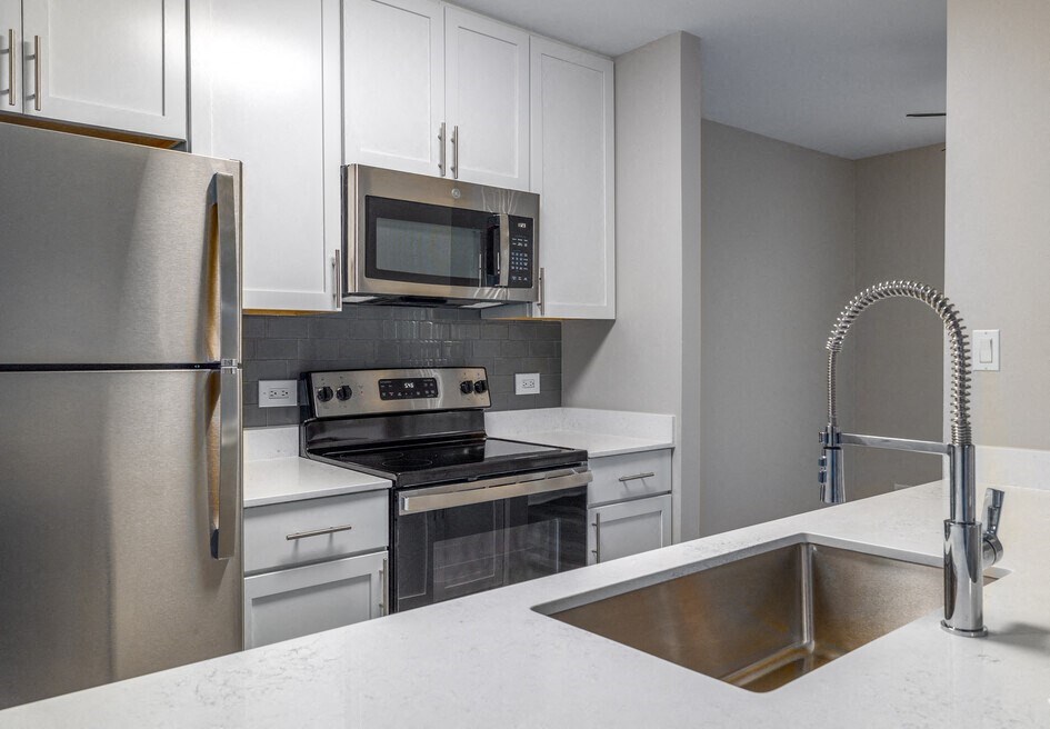 a kitchen with stainless steel appliances and white cabinets