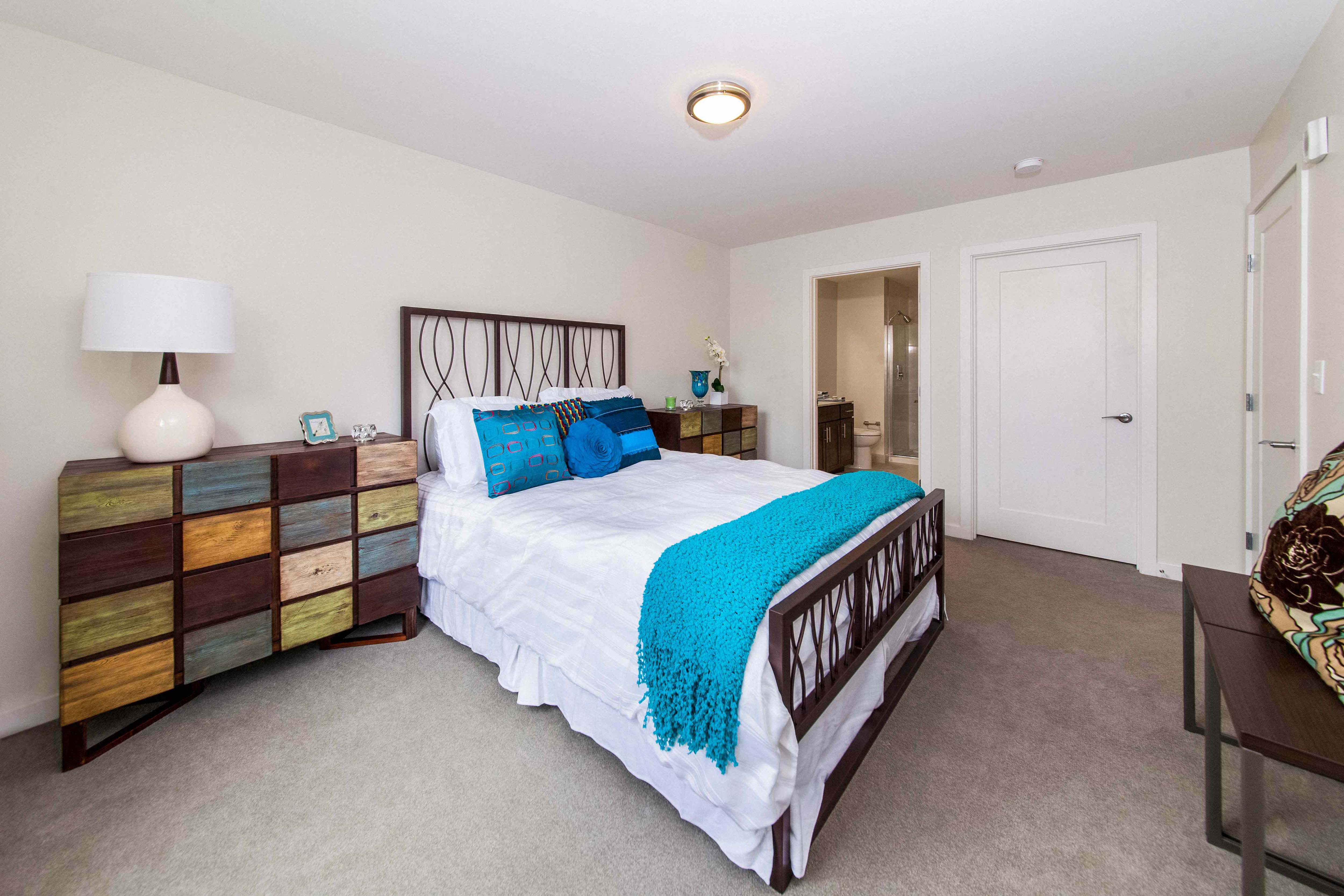 Spacious bedroom with built-in storage and aqua accent bedding