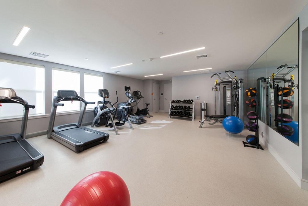 Modern fitness space with cardio equipment and stretching area