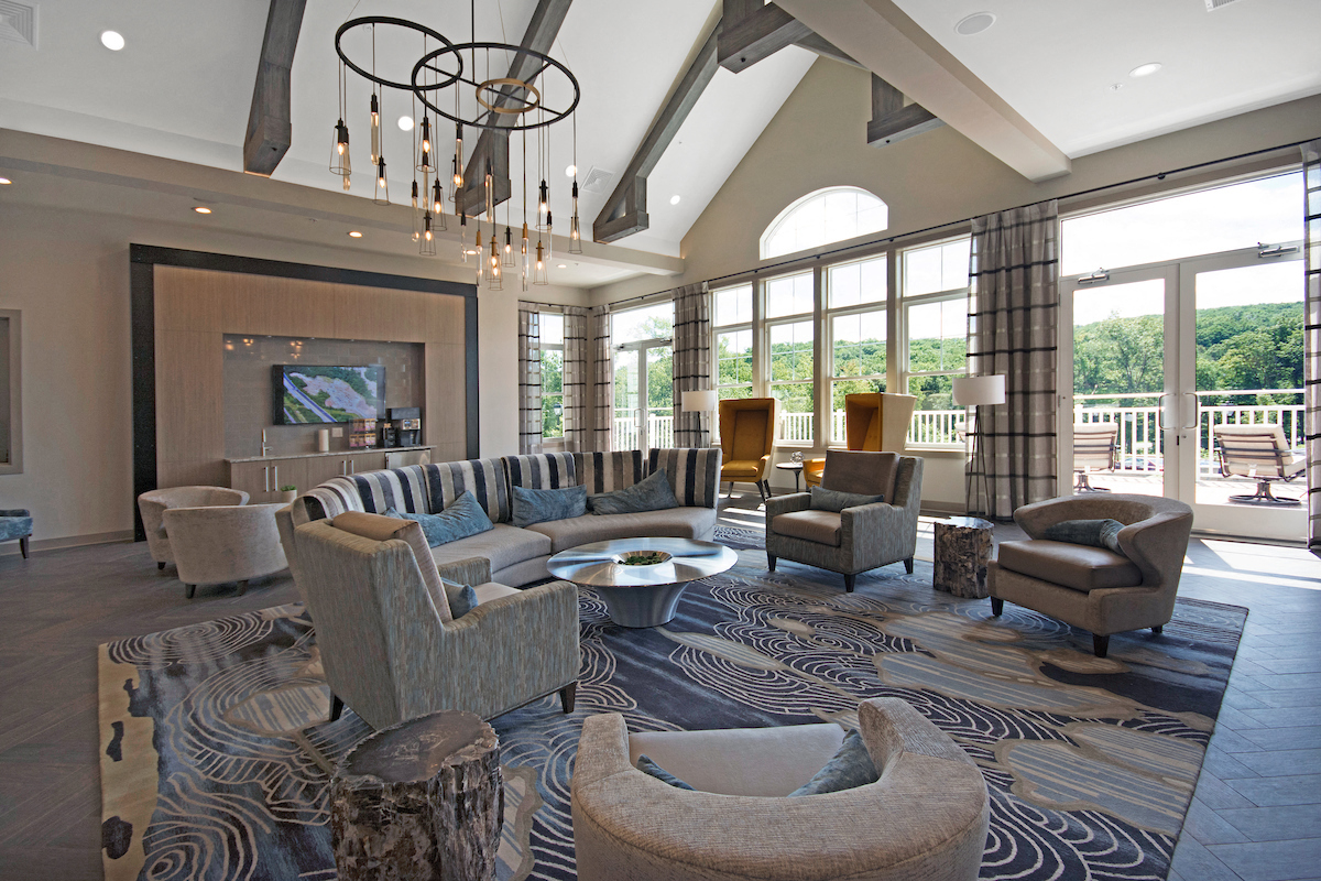 a large living room with couches and chairs and large windows