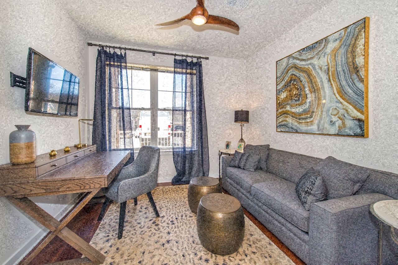 a living room with a couch and a table and a ceiling fan