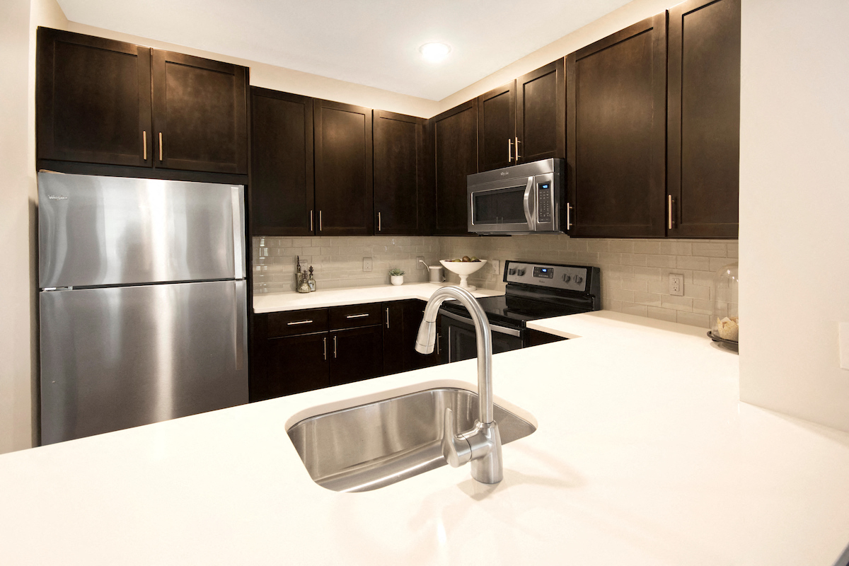 a kitchen with stainless steel appliances and black cabinets
