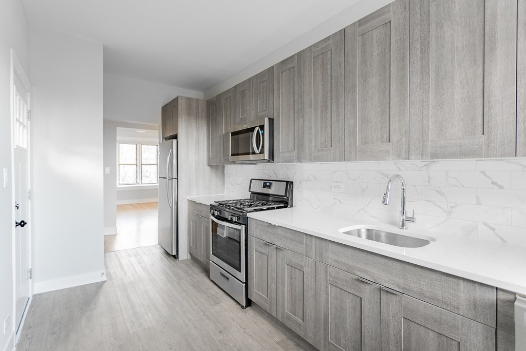 a kitchen with wooden cabinets and a sink and a stove
