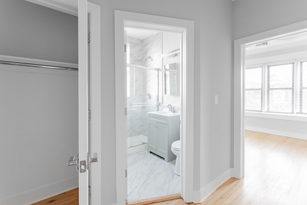 a room with a door open to a bathroom with a sink and a toilet