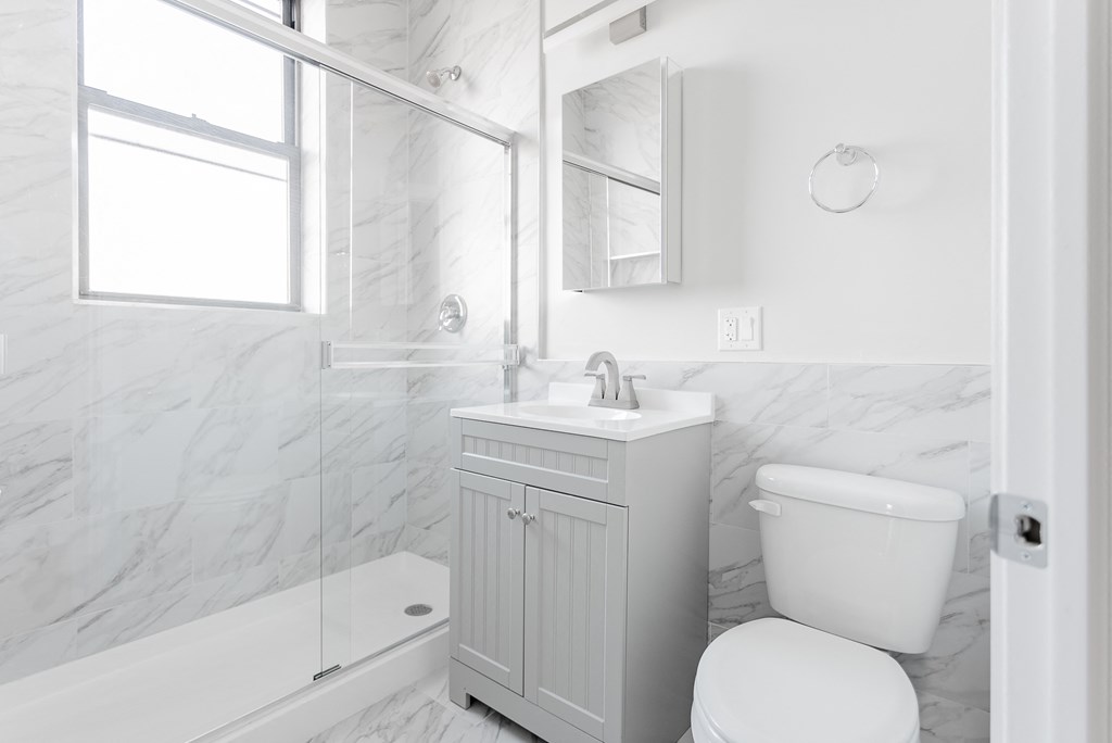 a white bathroom with a sink toilet and shower