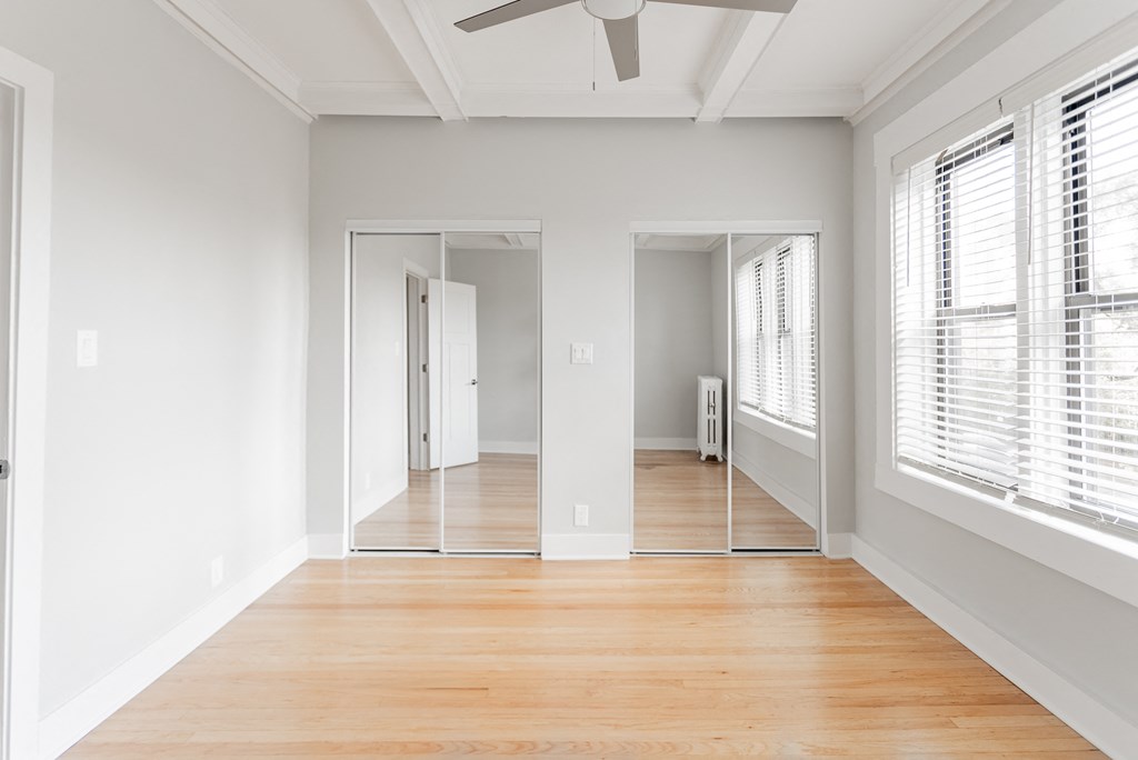 an empty living room with wood floors and white walls