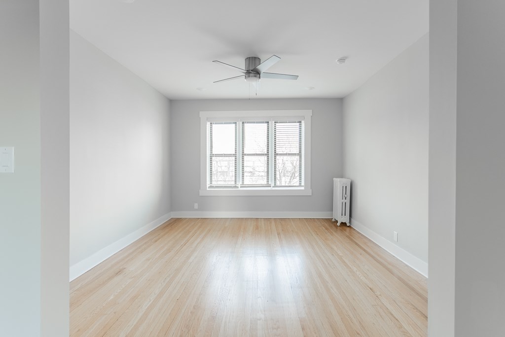 an empty room with wood floors and a window