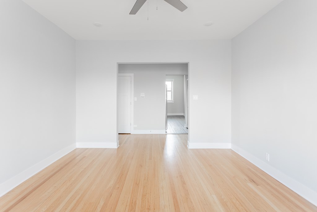 an empty living room with white walls and wood floors