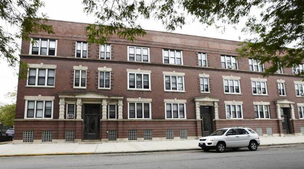 a white car parked in front of a brick building