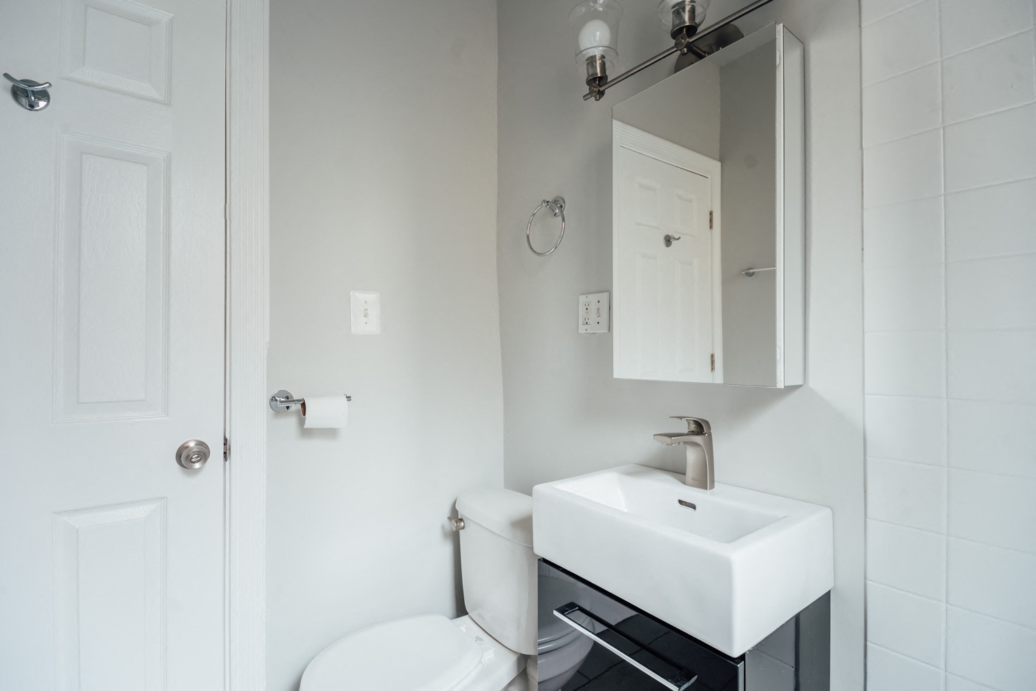 a white bathroom with a sink and a toilet
