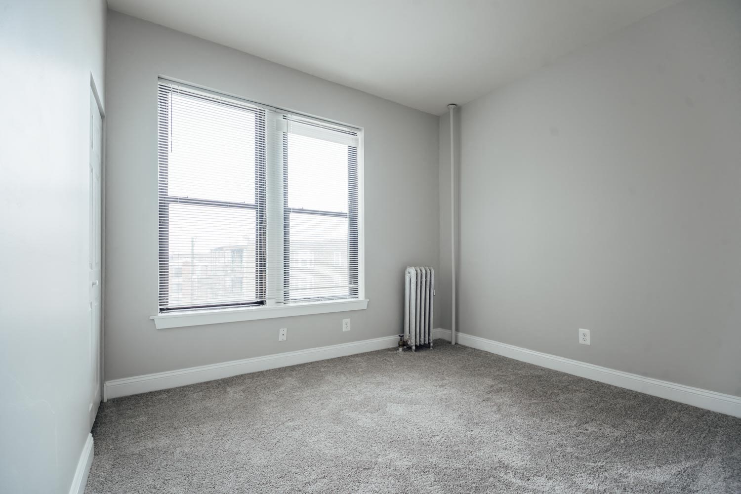 an empty room with a radiator and a window