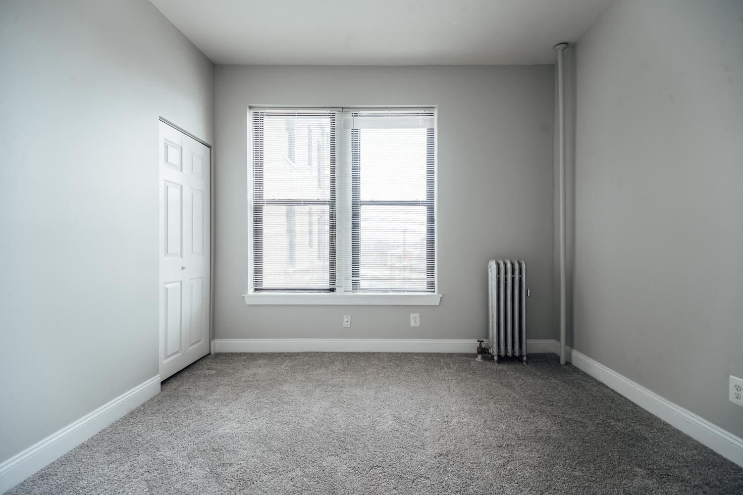 an empty room with a radiator and a window