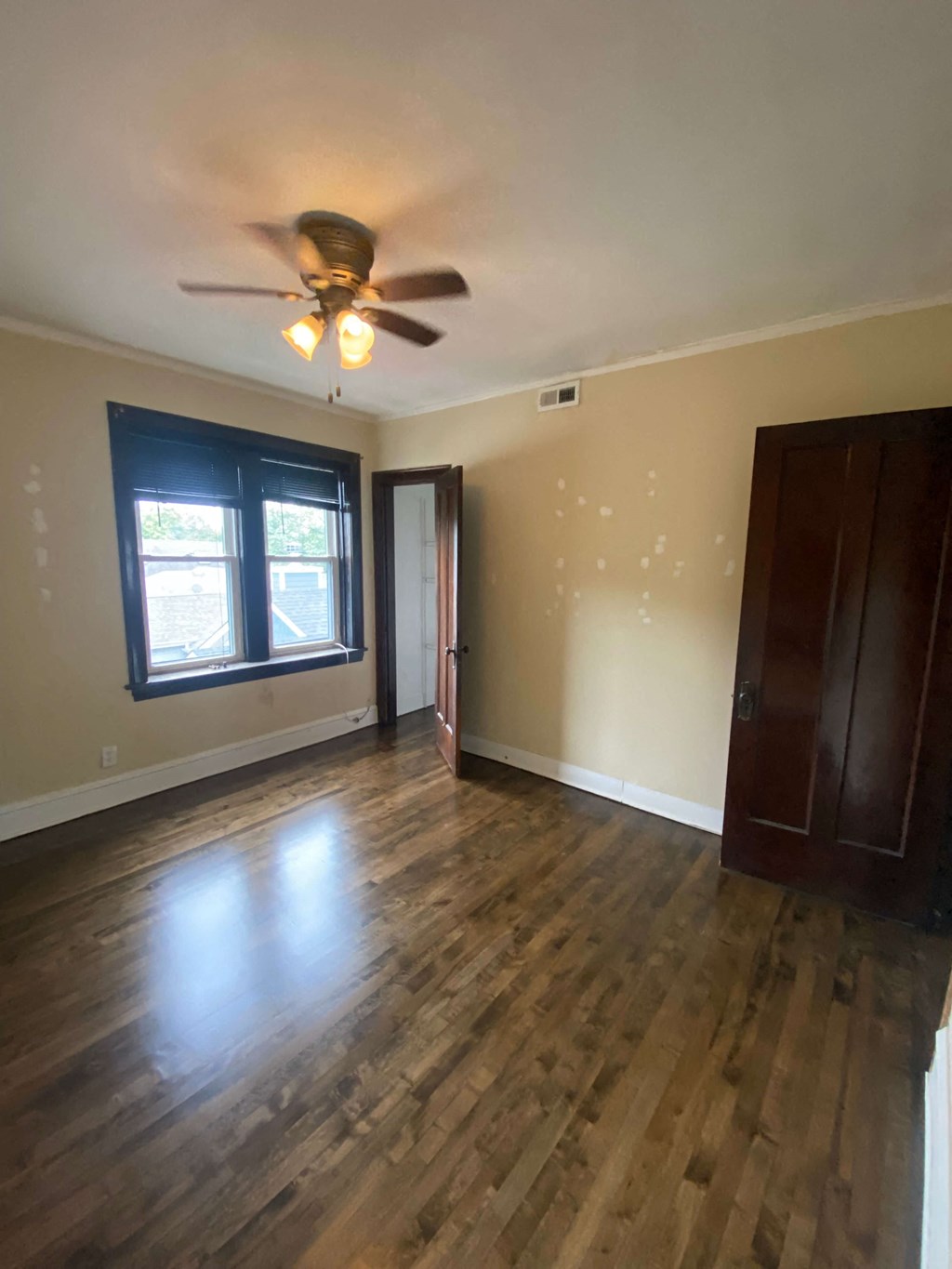an empty living room with wooden floors and a ceiling fan