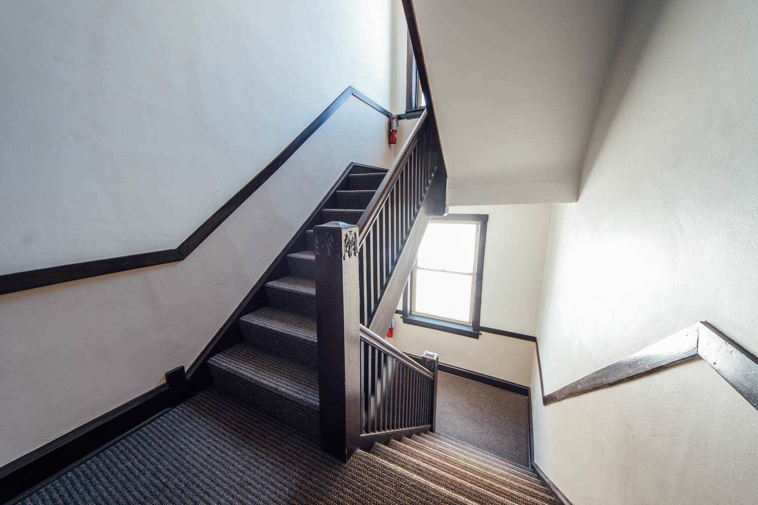 a set of stairs with a wooden railing and a window
