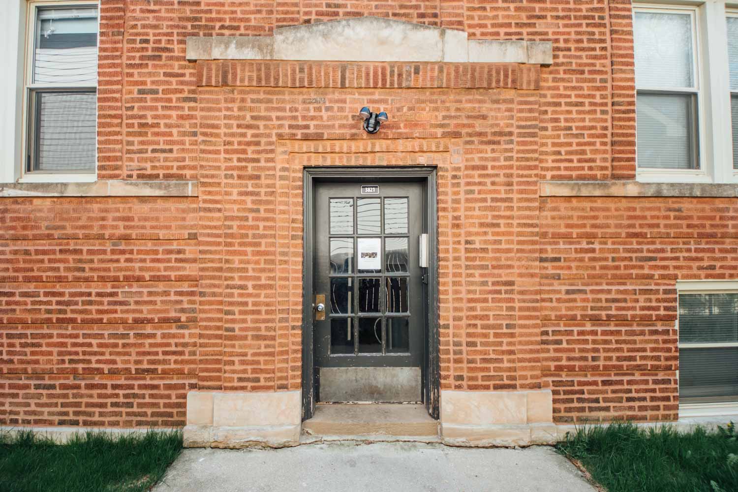 the front door of a brick building with a glass door