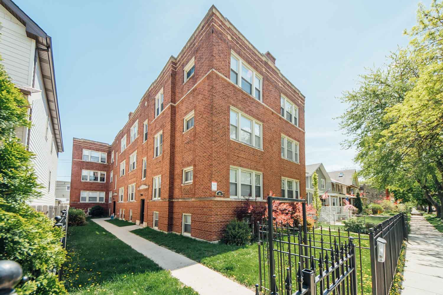a red brick building with a sidewalk in front of it