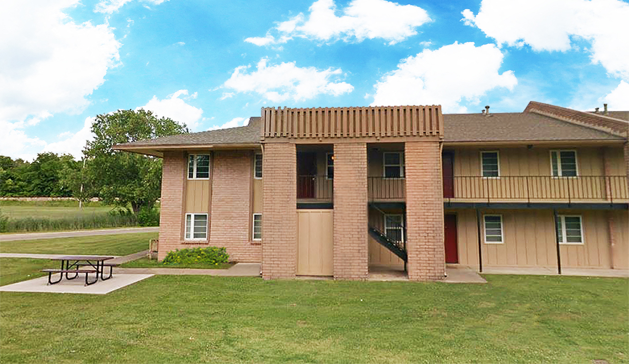 an apartment building with a picnic table in front of it