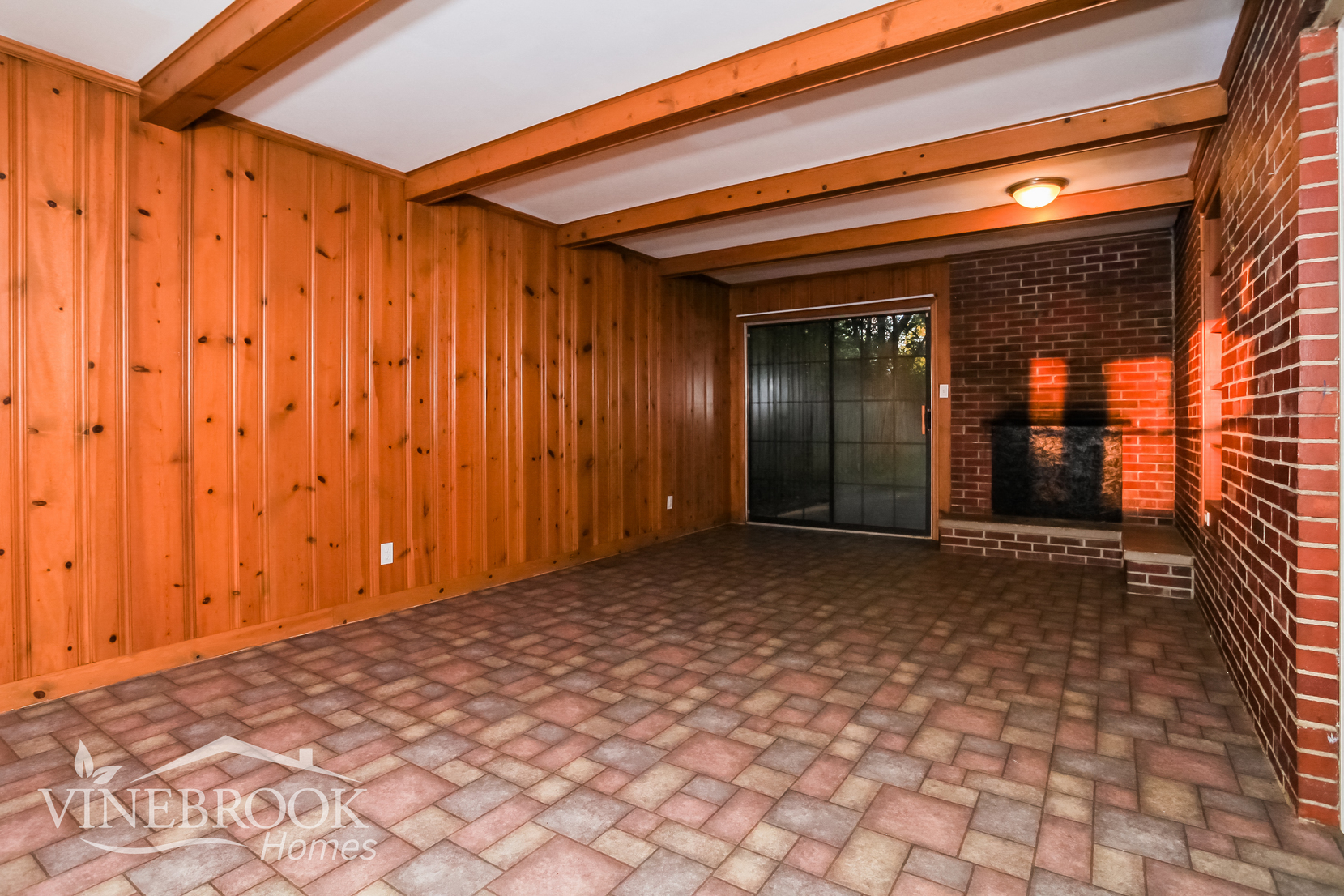 a large room with wood paneling and a brick wall and a door